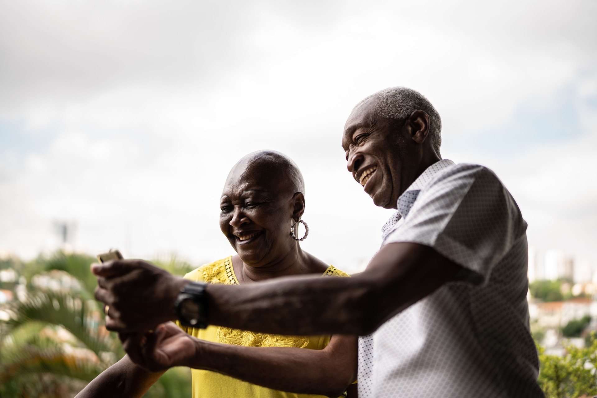 Senior man showing something on smartphone to his wife